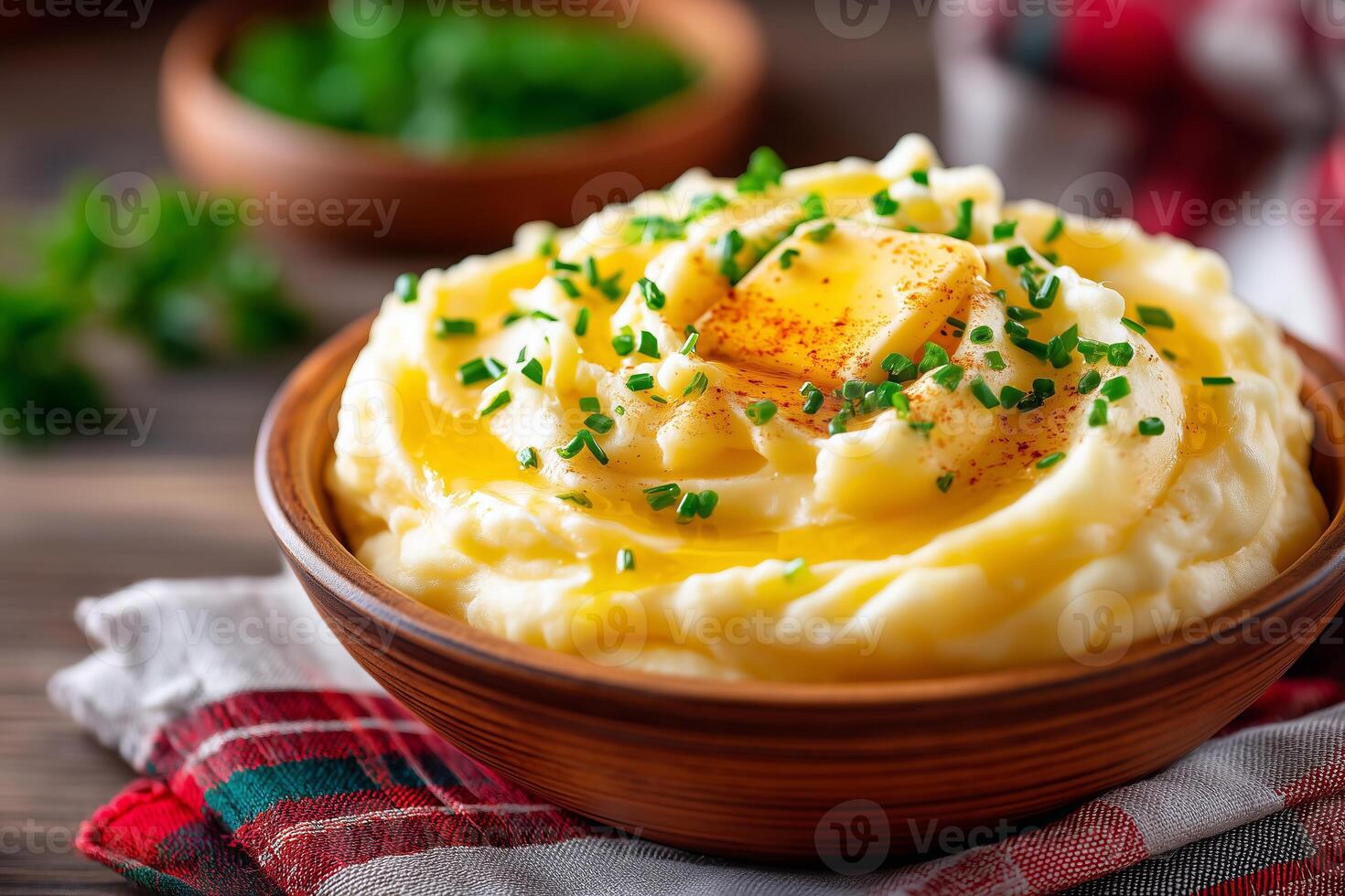 Mashed potatoes topped with melting butter and fresh chives served in a rustic bowl on a linen tablecloth. Creamy mashed potatoes are generously topped with melting butter and freshly chopped chives photo