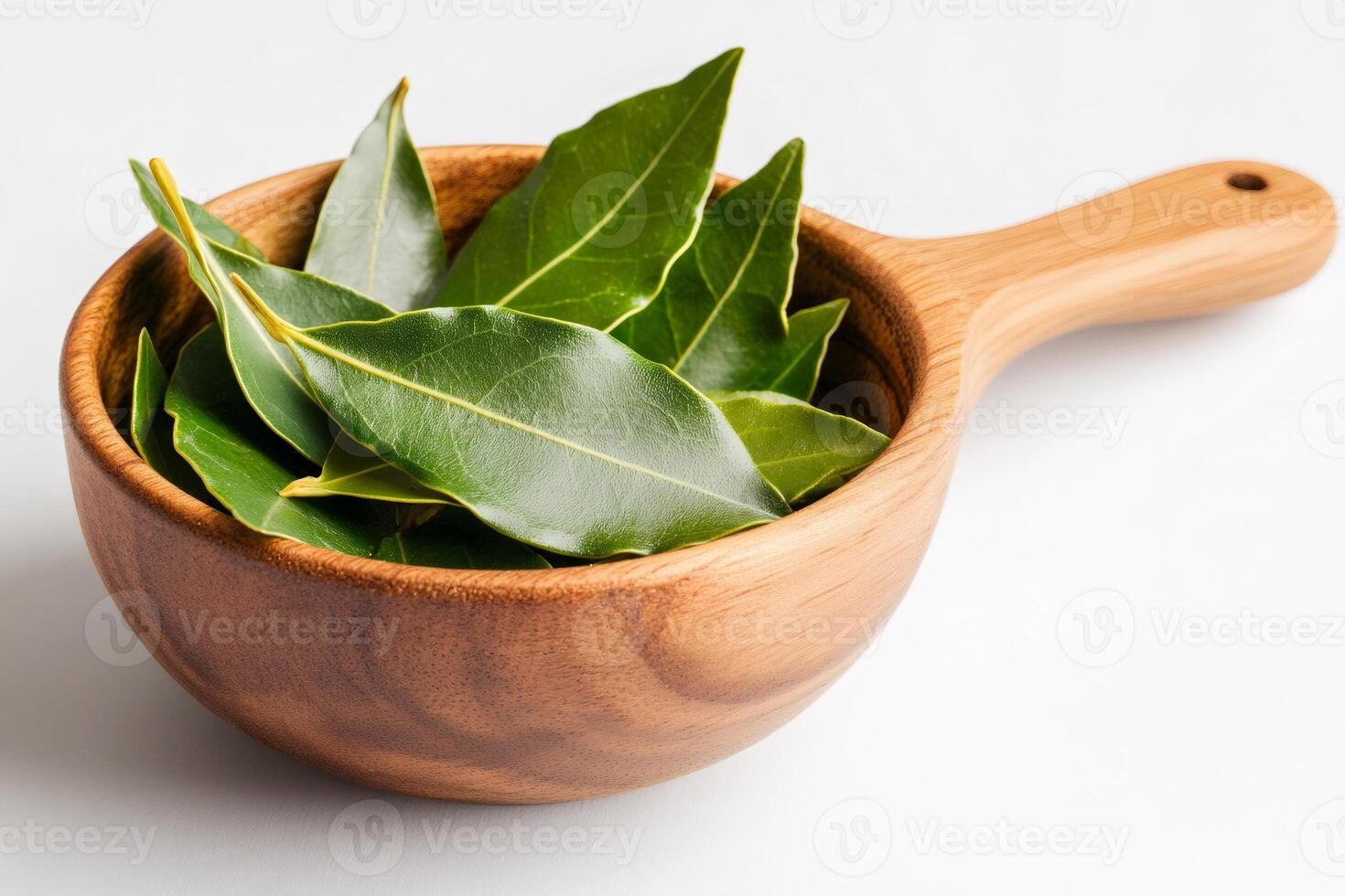 Fresh bay leaves sit in a wooden bowl, ready to enhance culinary creations photo