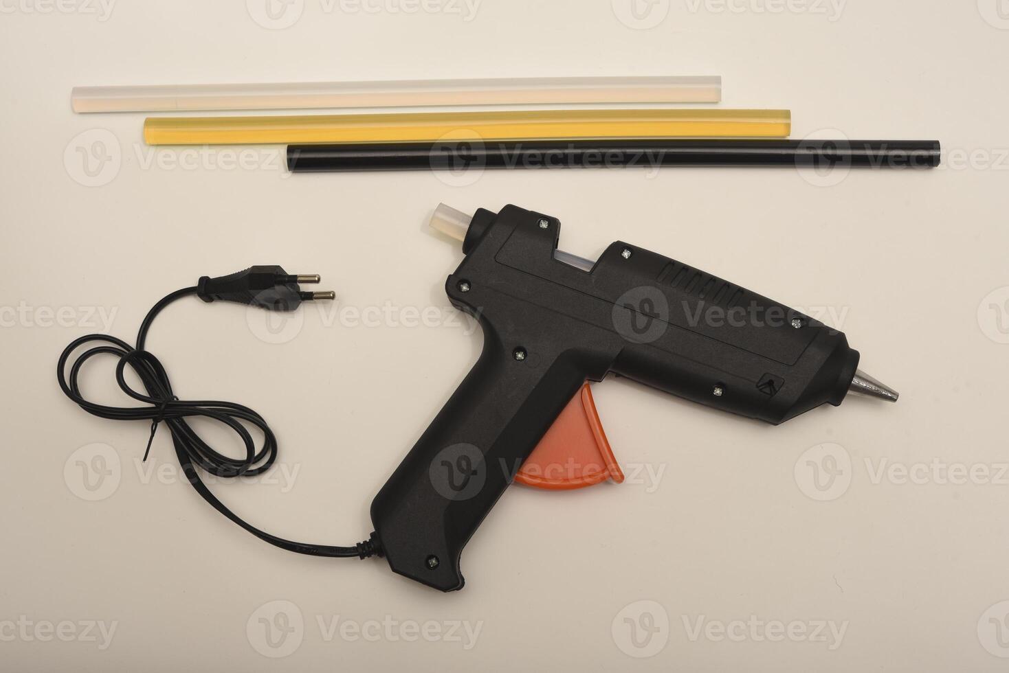 Black glue gun on a white background. A tool for gluing. photo
