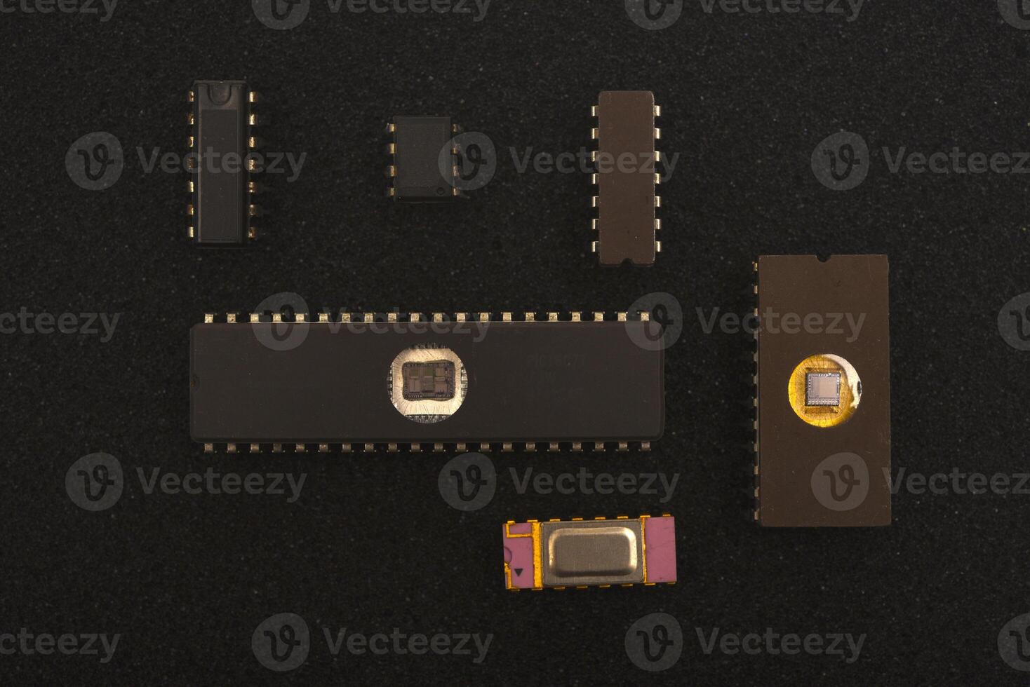 Historical computing hardware assortment. Several microchips on black foam. Old integrated circuits for radio electronics. photo