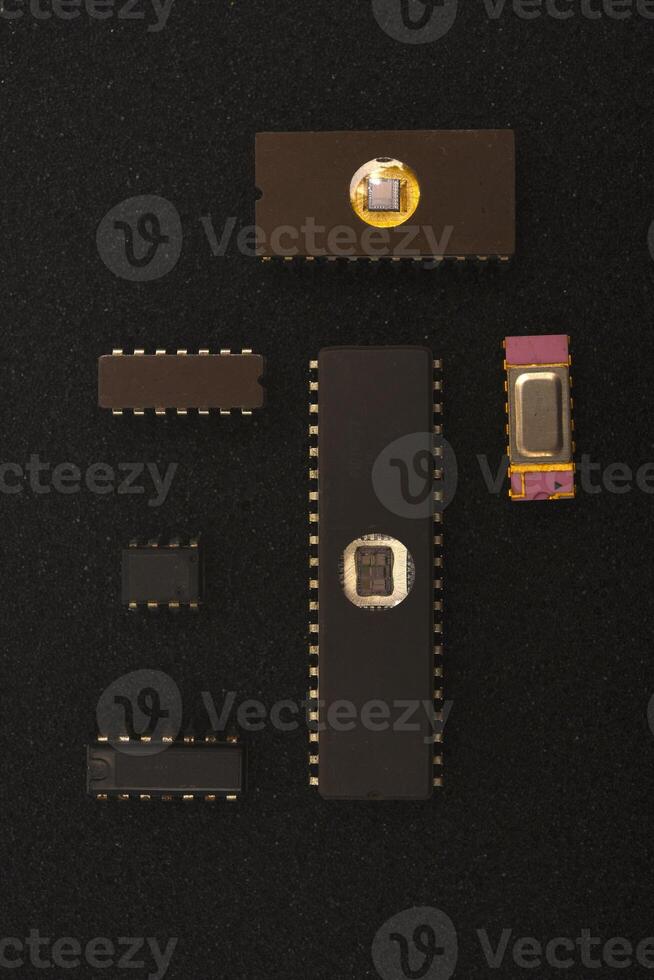 Obsolete radio electronics parts collection. Several microchips on black foam. Old integrated circuits for radio electronics. photo