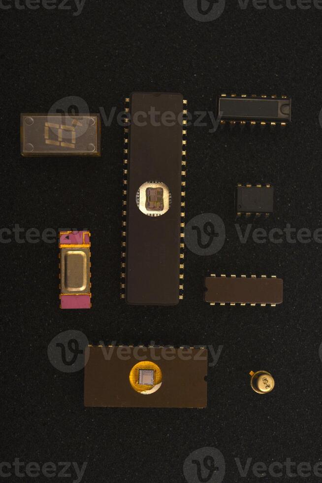 Outdated technology components display. Several microchips on black foam. Old integrated circuits for radio electronics. photo