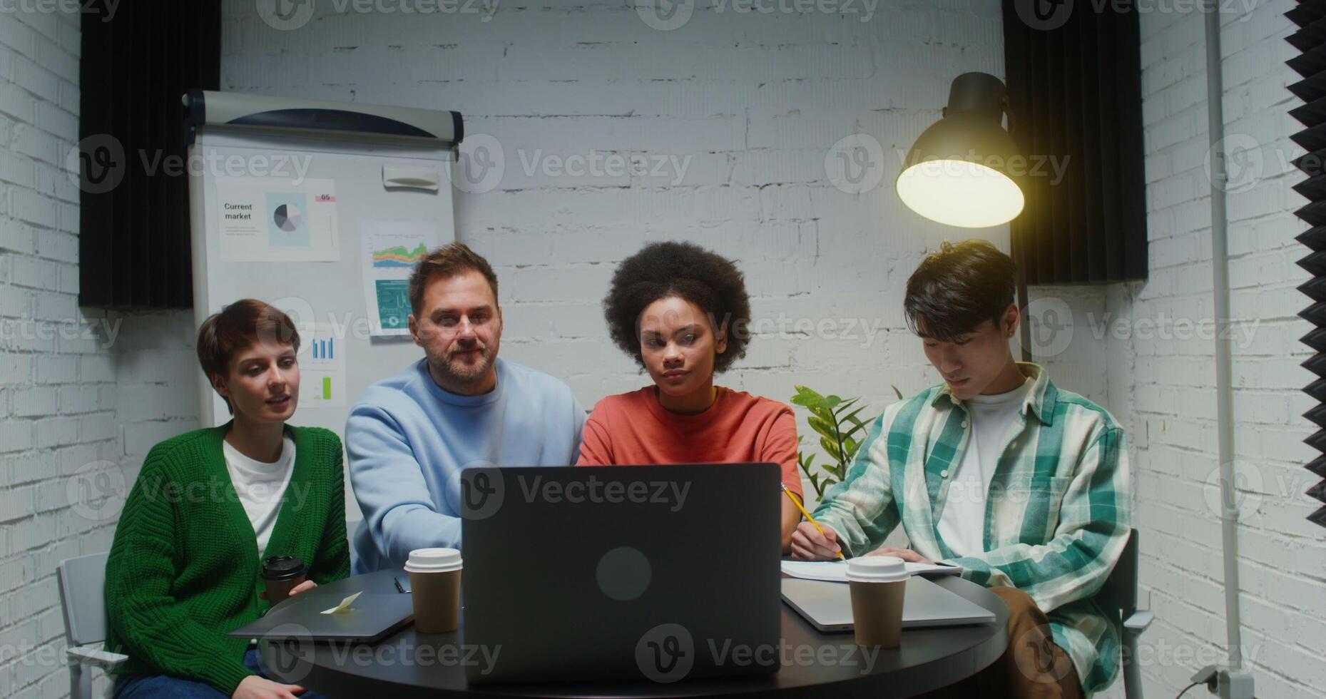 A group of young entrepreneurs chatting on a laptop while sitting in office photo