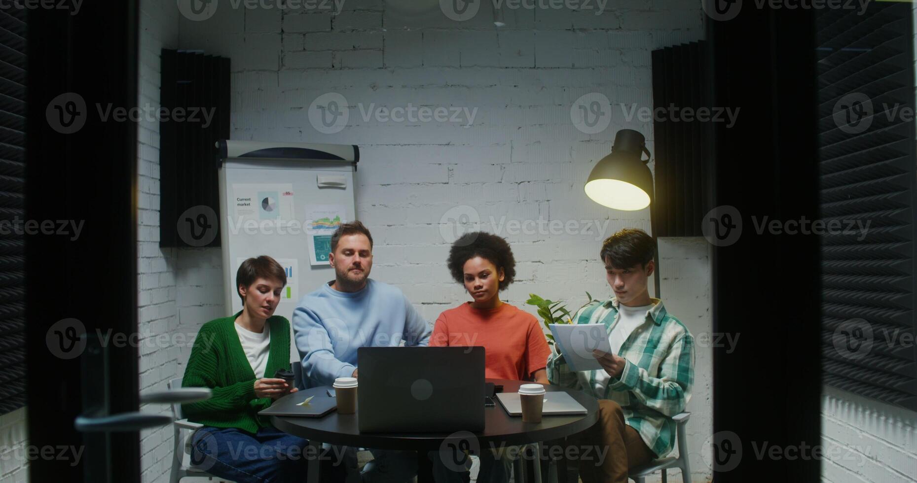 Group of young entrepreneurs watching presentation of new product on laptop photo