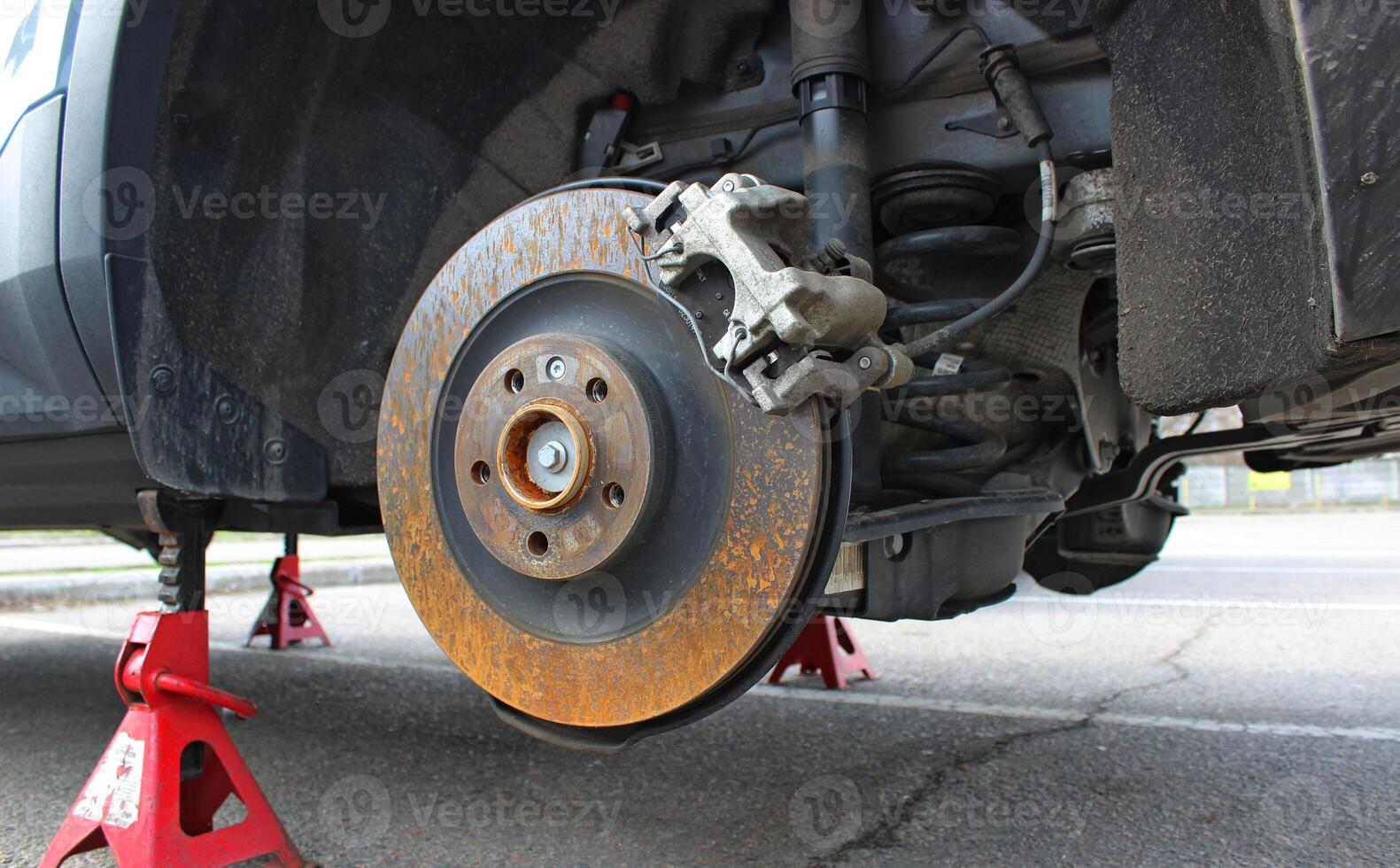 Dismantled wheel provides access to repair of the shock absorbers, suspension and braking system of the car photo