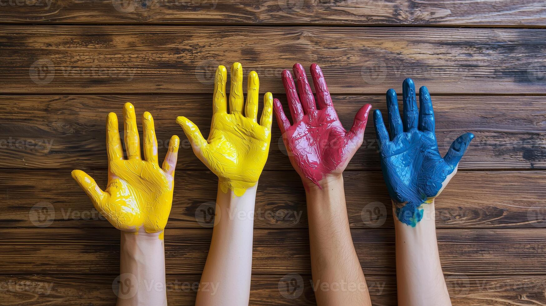 Hands with different colors of paint on them, on a wooden background. 4 photo
