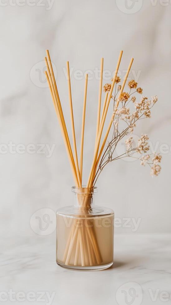 Decoration with aroma sticks in a glass vase combined with dried flowers in a minimalistic setup on a light surface photo