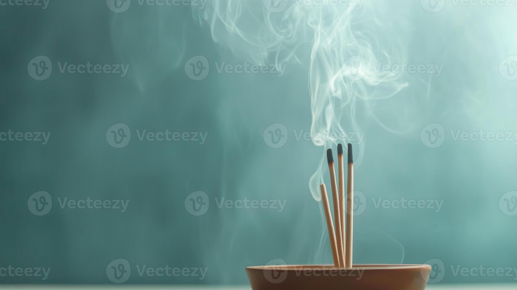 Incense sticks release aromatic smoke in a calming indoor setting at dusk photo