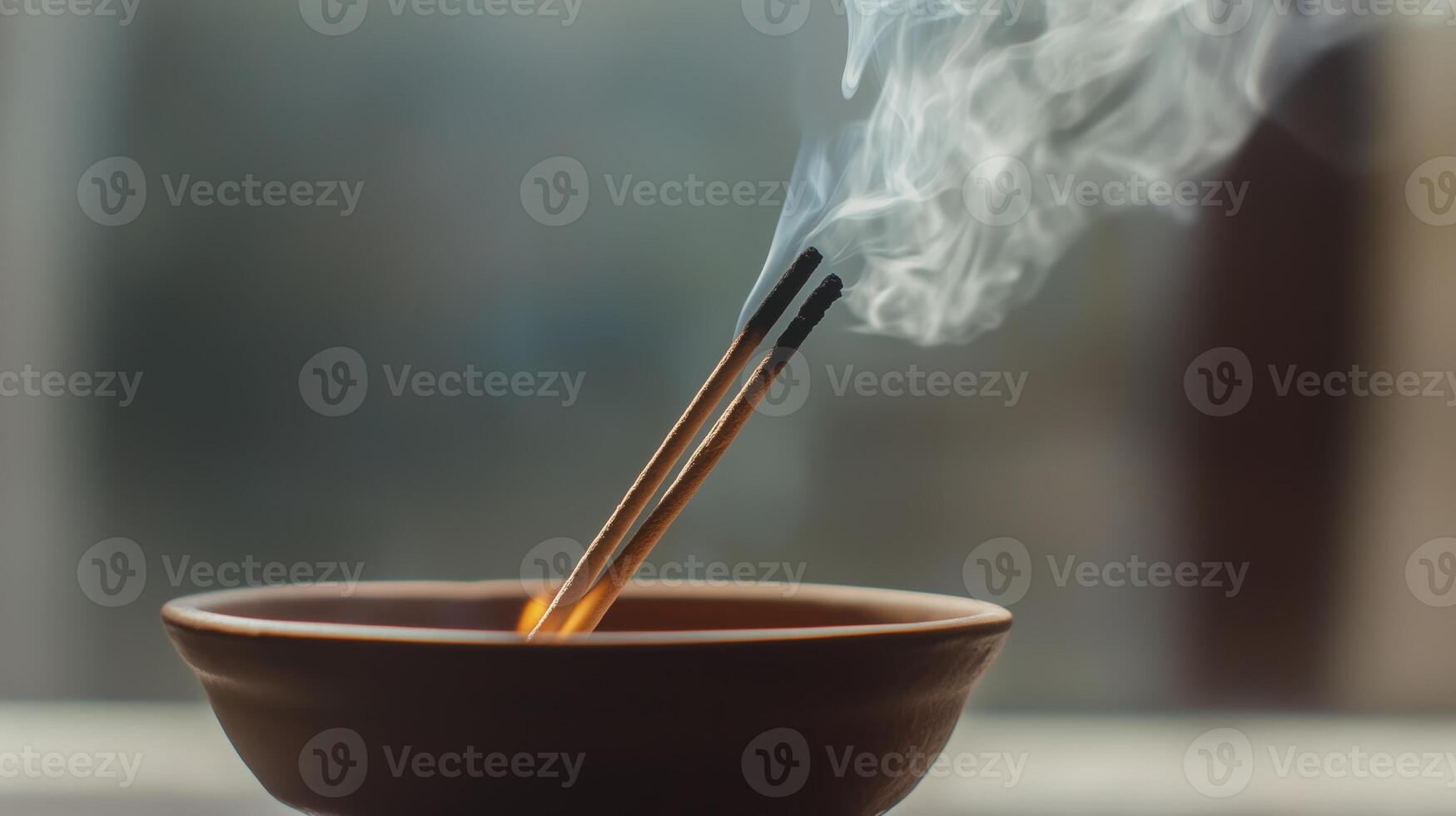 Incense sticks releasing smoke in a ceramic holder, creating a tranquil atmosphere indoors photo