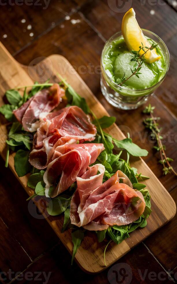 Delicate slices of prosciutto are artfully arranged on a bed of fresh greens, served on a wooden board photo