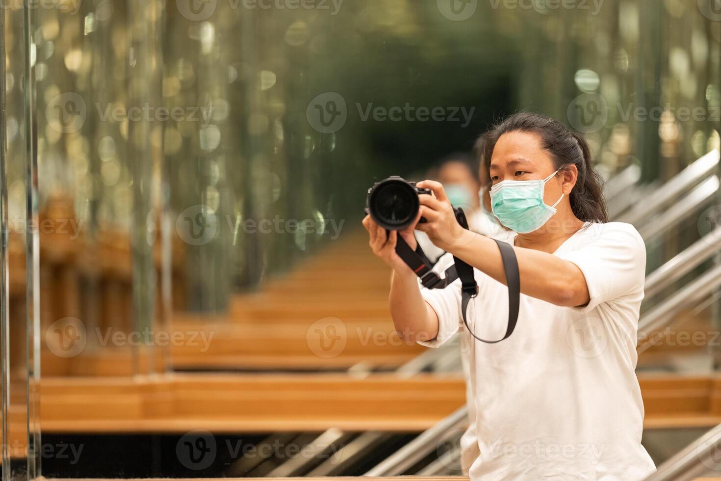 Photographer using camera to taking Self Portrait in 3the mirror.Photographer with a black SLR camera. photo