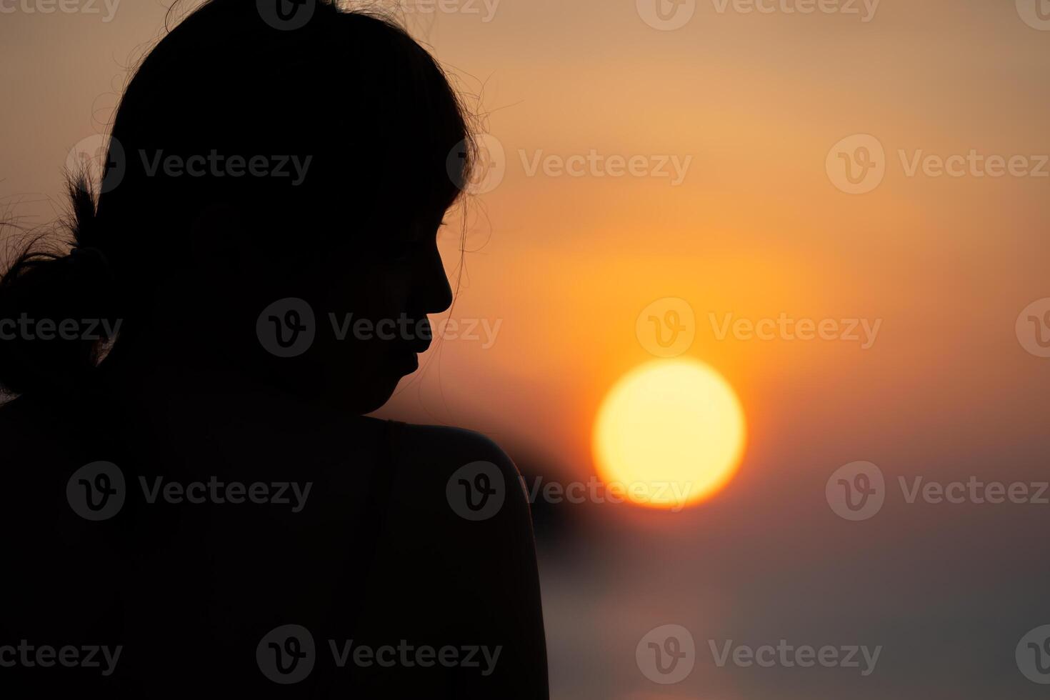 Asian Woman in Silhouette mood and tone of picture wit2h orange warm sunset blurs, background on Kata Beach, Phuket province, Thailand. photo