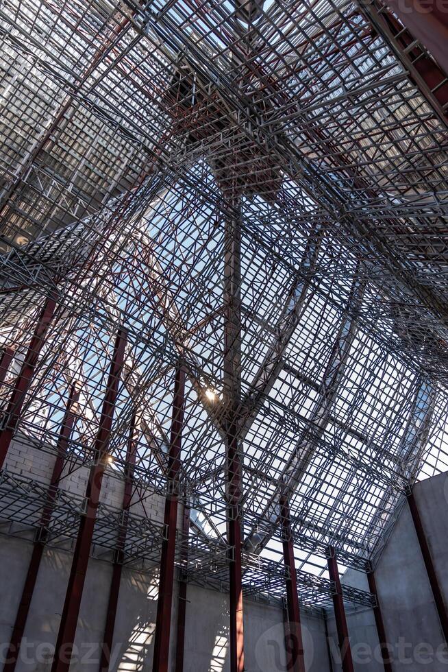 Uprisen angle photo shot of the huge steel roof frame 1structure detail under construction at the work site.