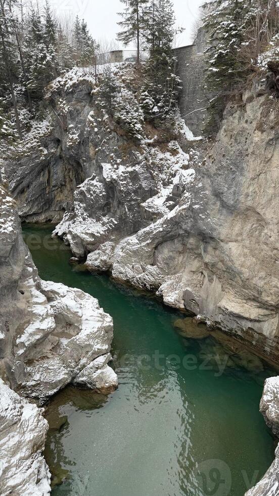 Emerald river Lech flowing through a snowy gorge near Fuessen photo