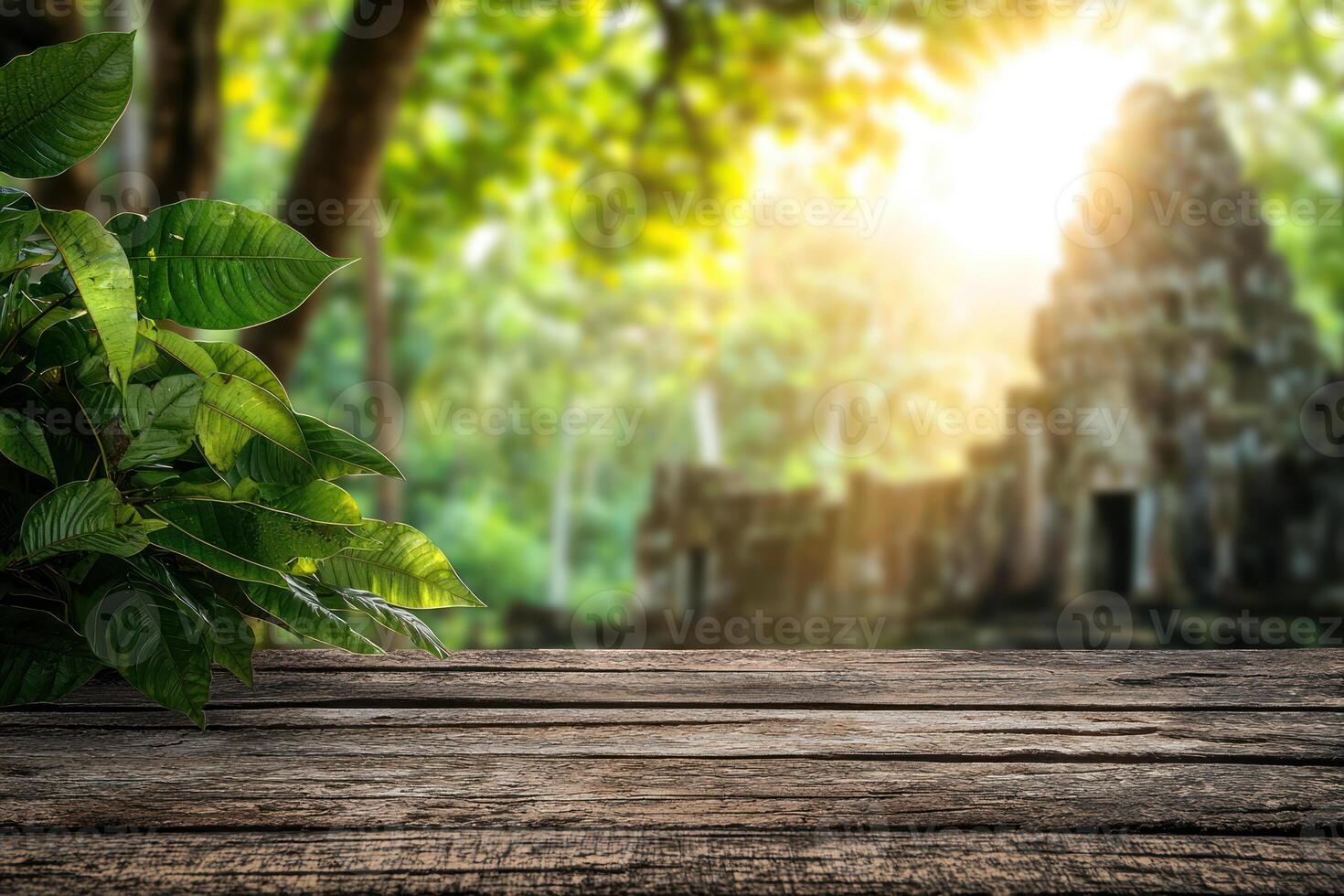 rustic wooden table with lush green leaves foreground and blurred ancient temple ruin surrounded by dense jungle background photo