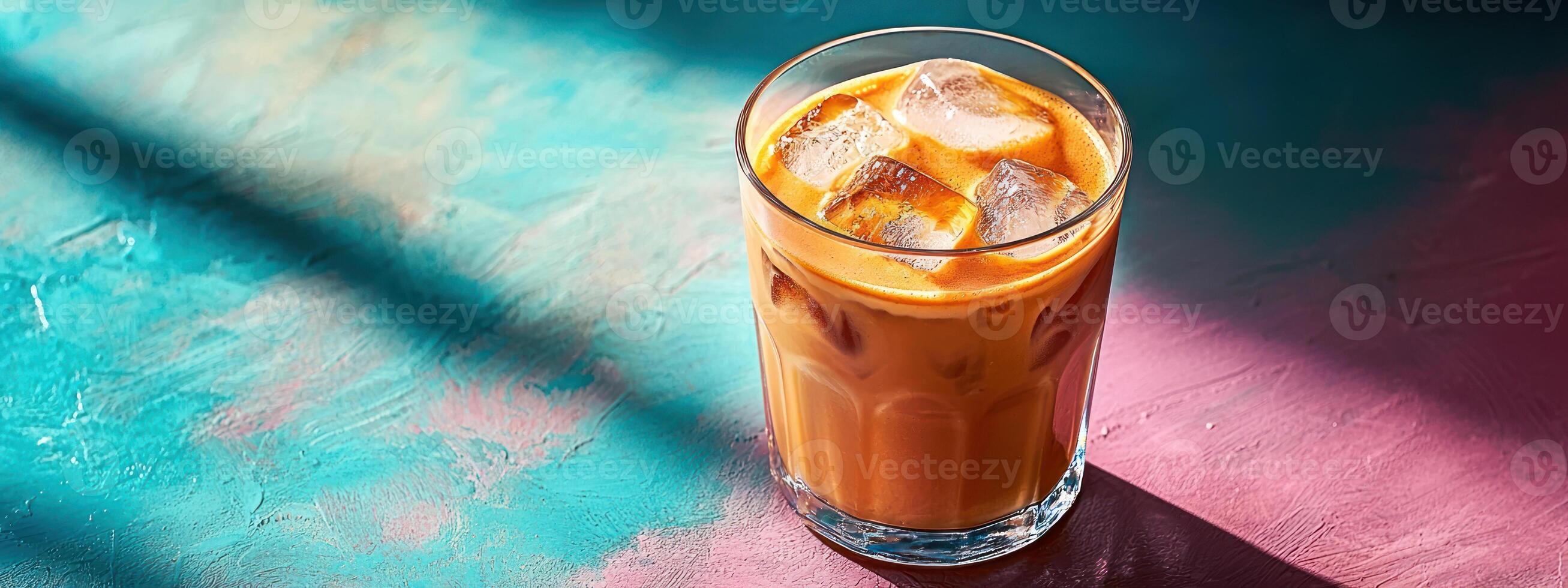 refreshing iced latte served in transparent glass, placed on vibrant, colorful background with sunlight casting soft shadows photo