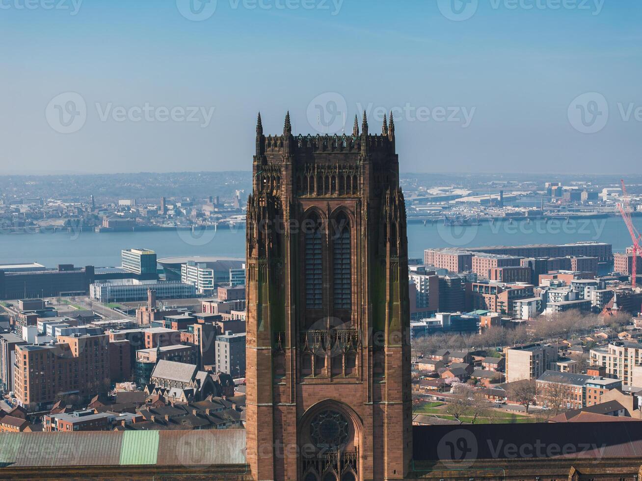 Aerial view of Liverpool featuring the Gothic Revival Liverpool Cathedral, urban buildings, the River Mersey, docks, and industrial waterfront areas. photo