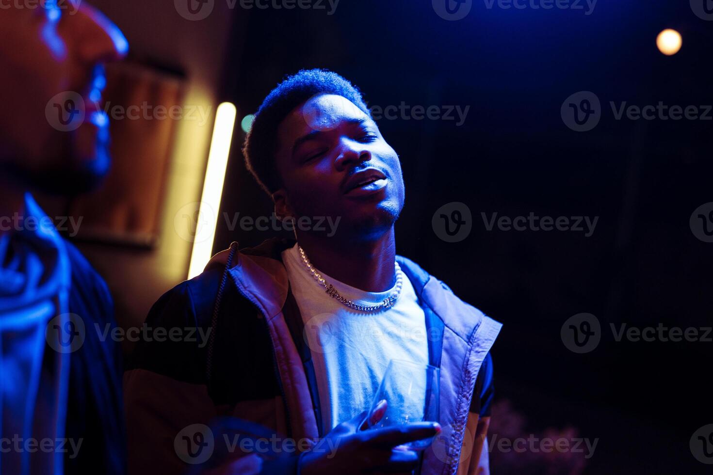 Celebrating music and connection at a vibrant night gathering in an urban setting under blue lighting photo