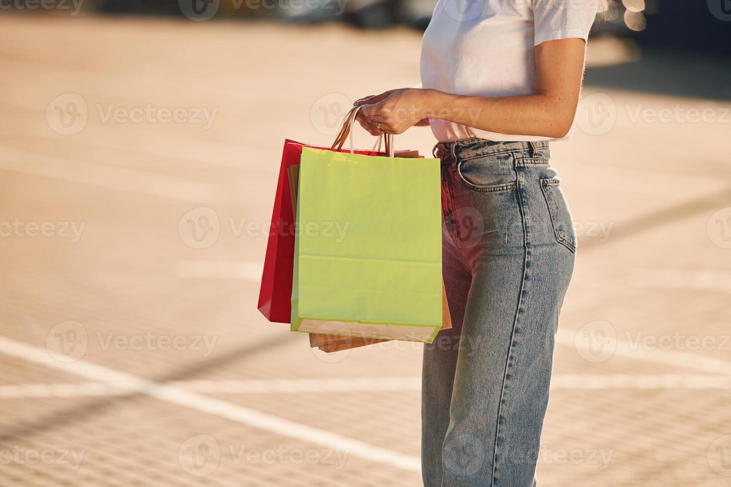 Close up view.. Beautiful ,woman in casual clothes is holding shopping bags, outdoors photo