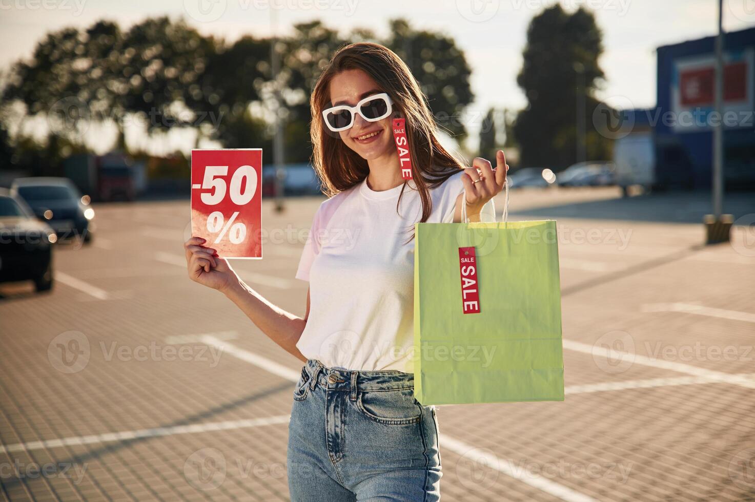 Big sale.. Beautiful woman in casual clothes is holding shopping bags, outdoors photo