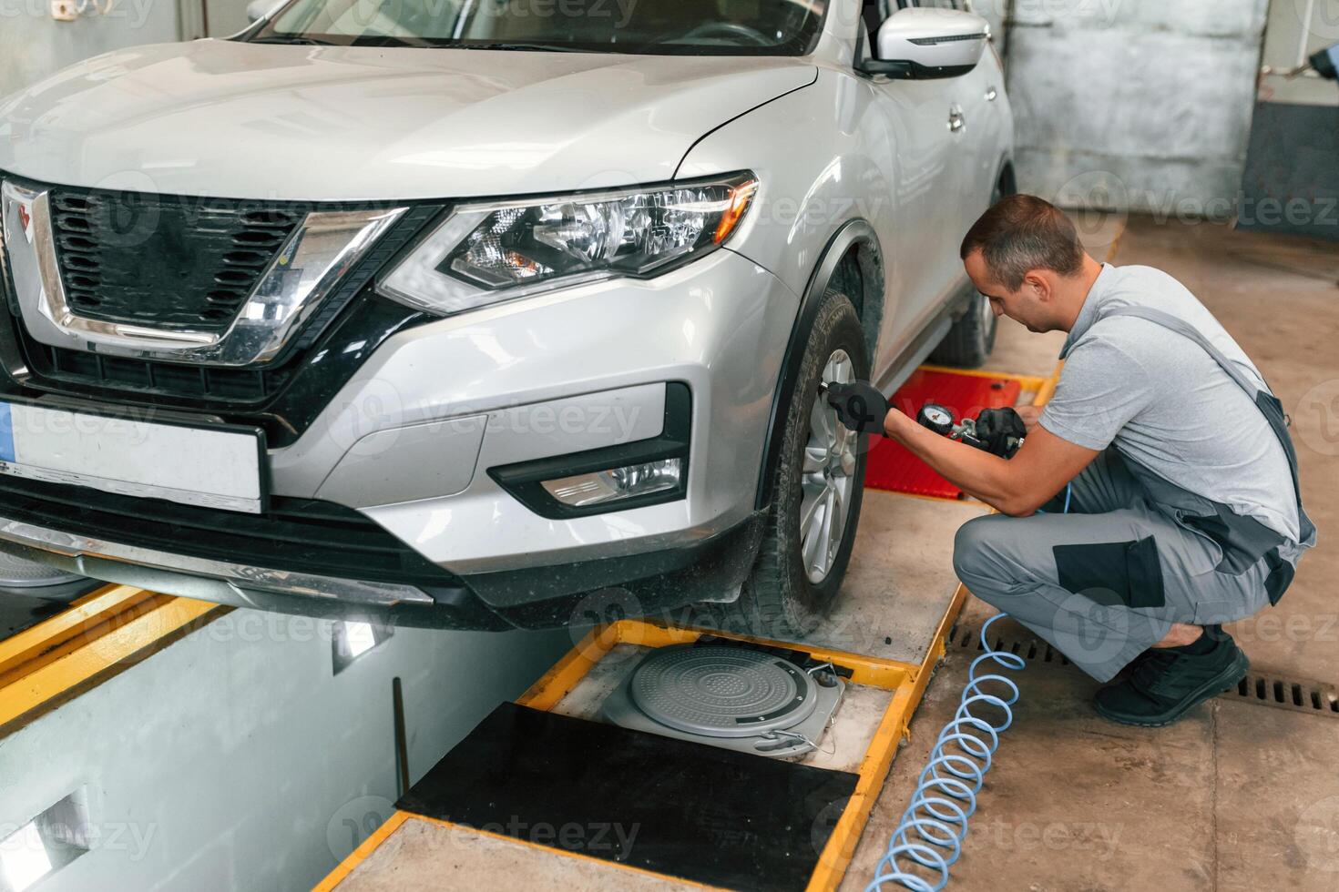 Adjusting ,the tire. Man is works in ,the automobile repairing salon photo