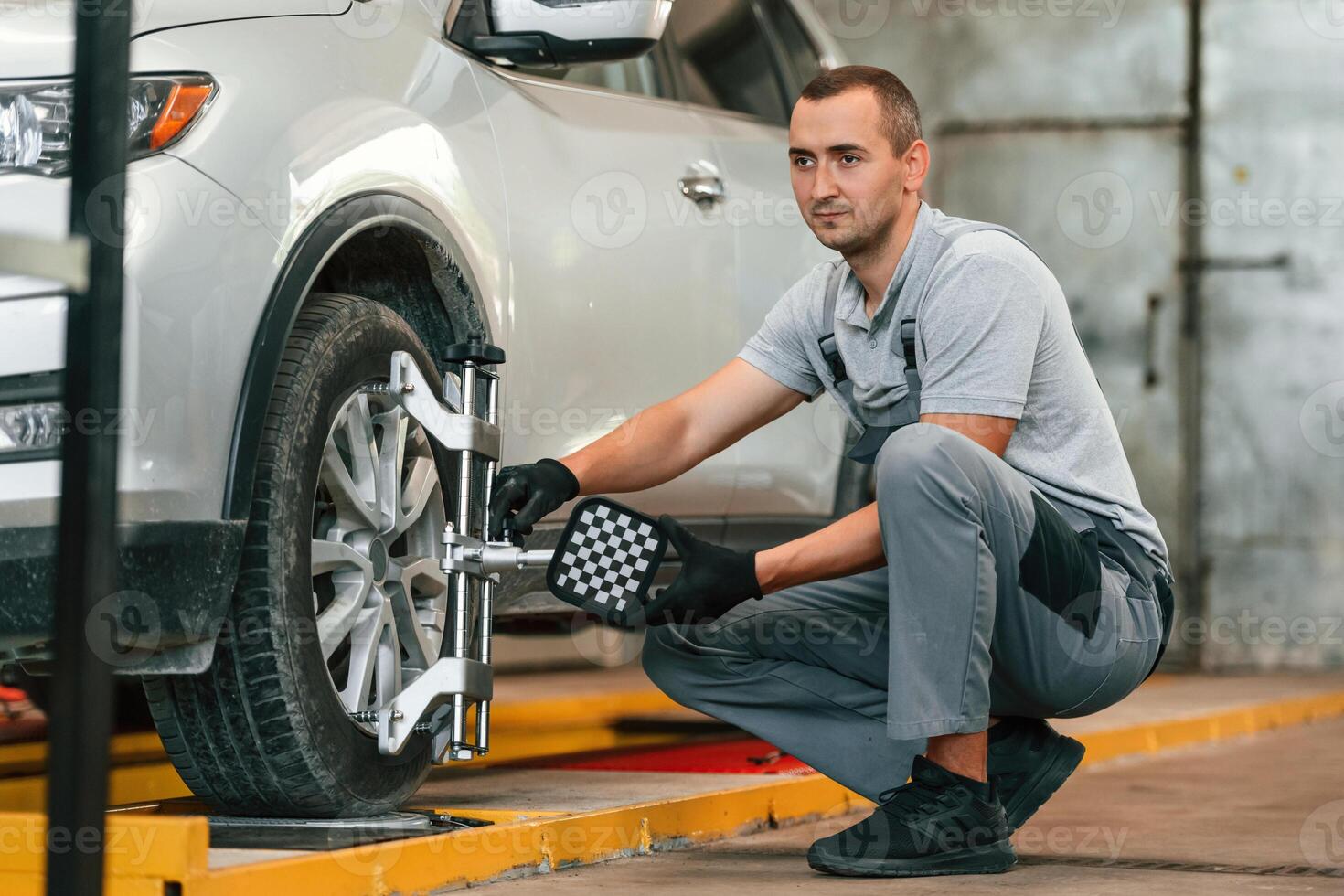 Adjusting ,the tire. Man is works in the automobile repairing salon photo