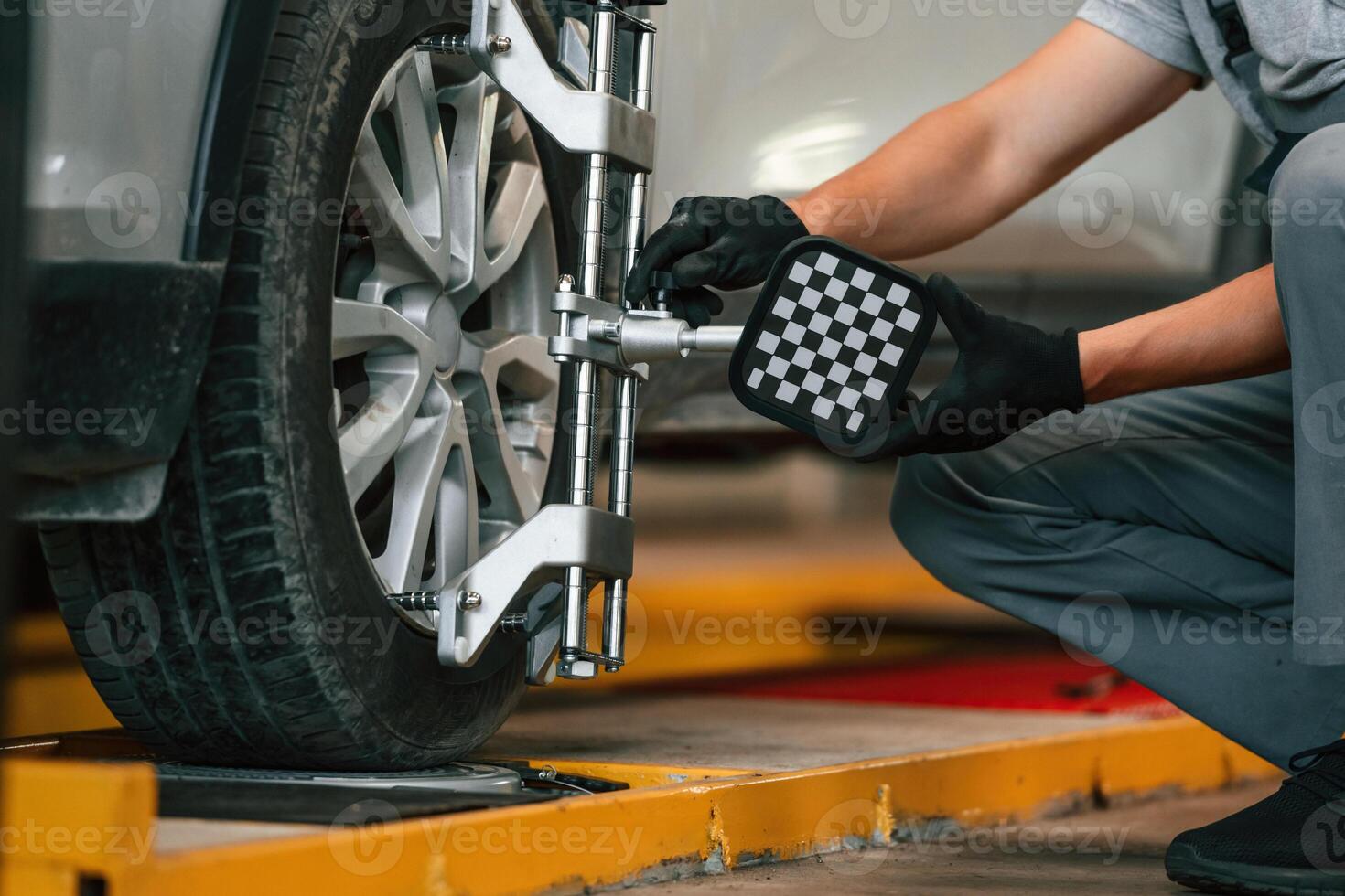 Adjusting the ,tire. Man is works in the automobile repairing salon photo