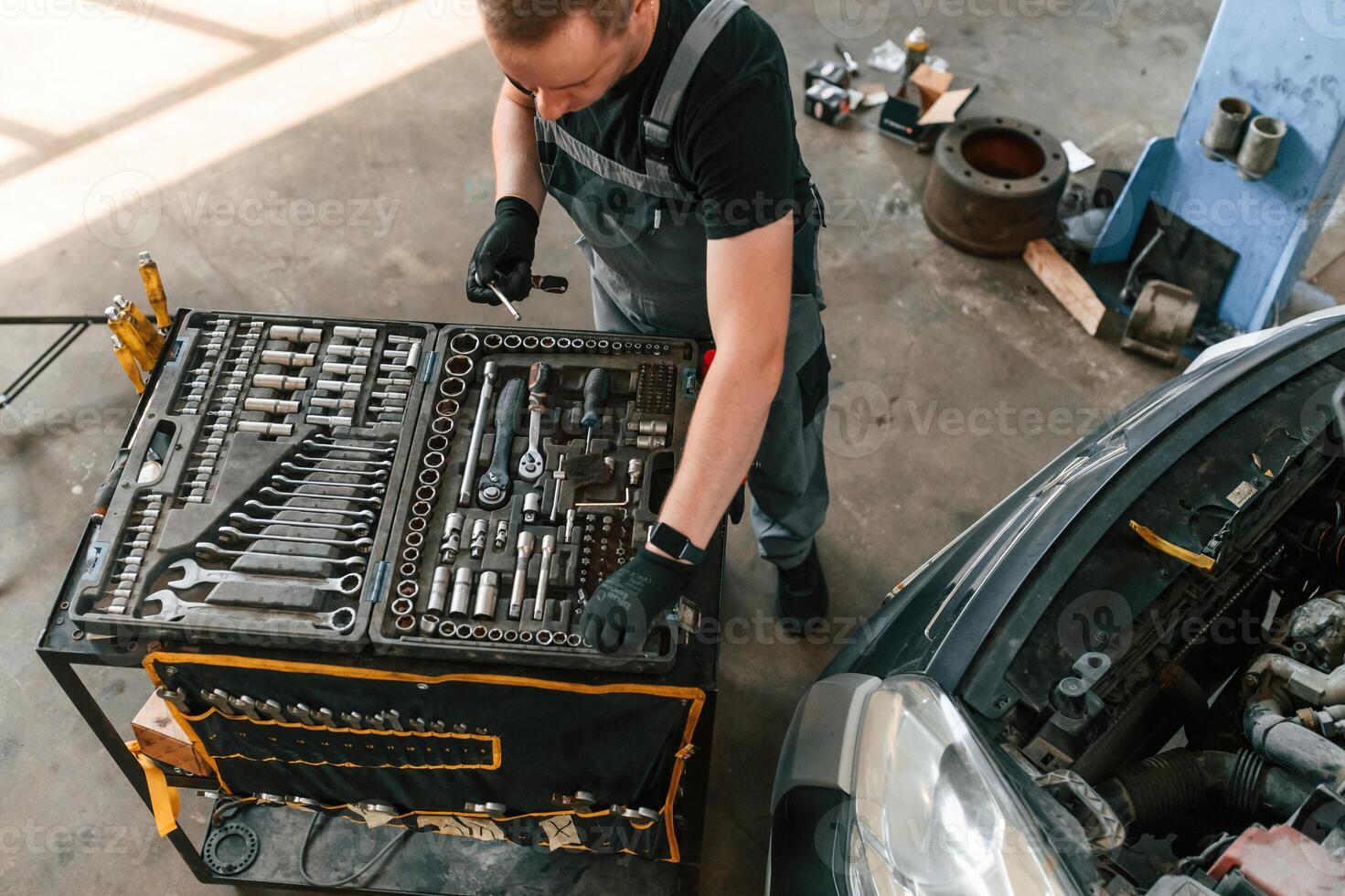 Top view ,of employee that standing by the toolbox. Man is works in the automobile repairing salon photo