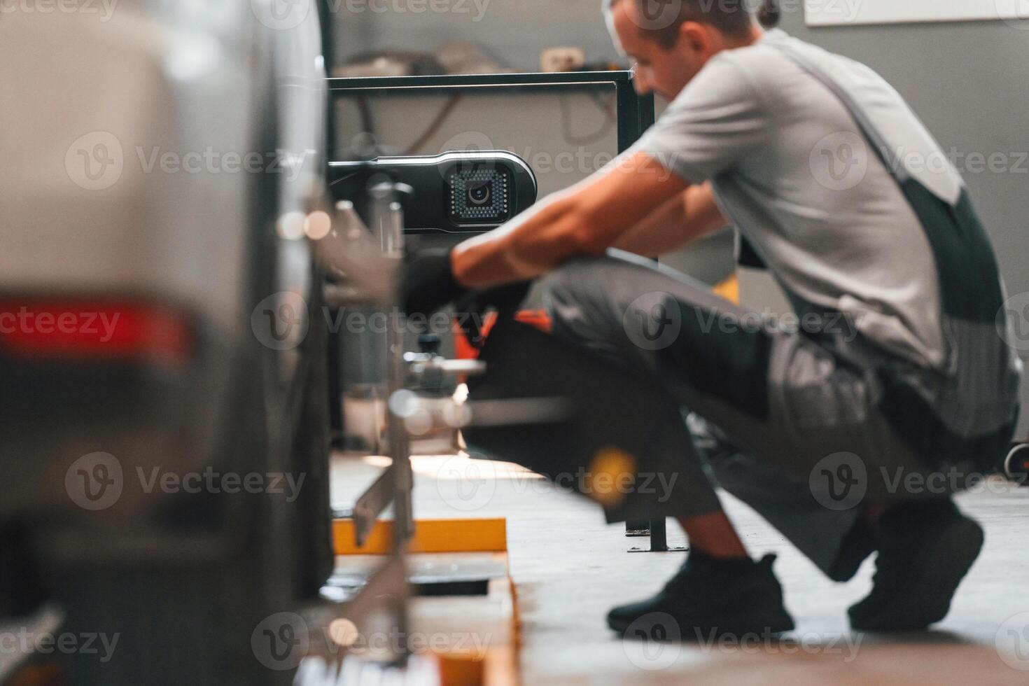 Changing the tire. Man is ,works in the automobile repairing salon photo