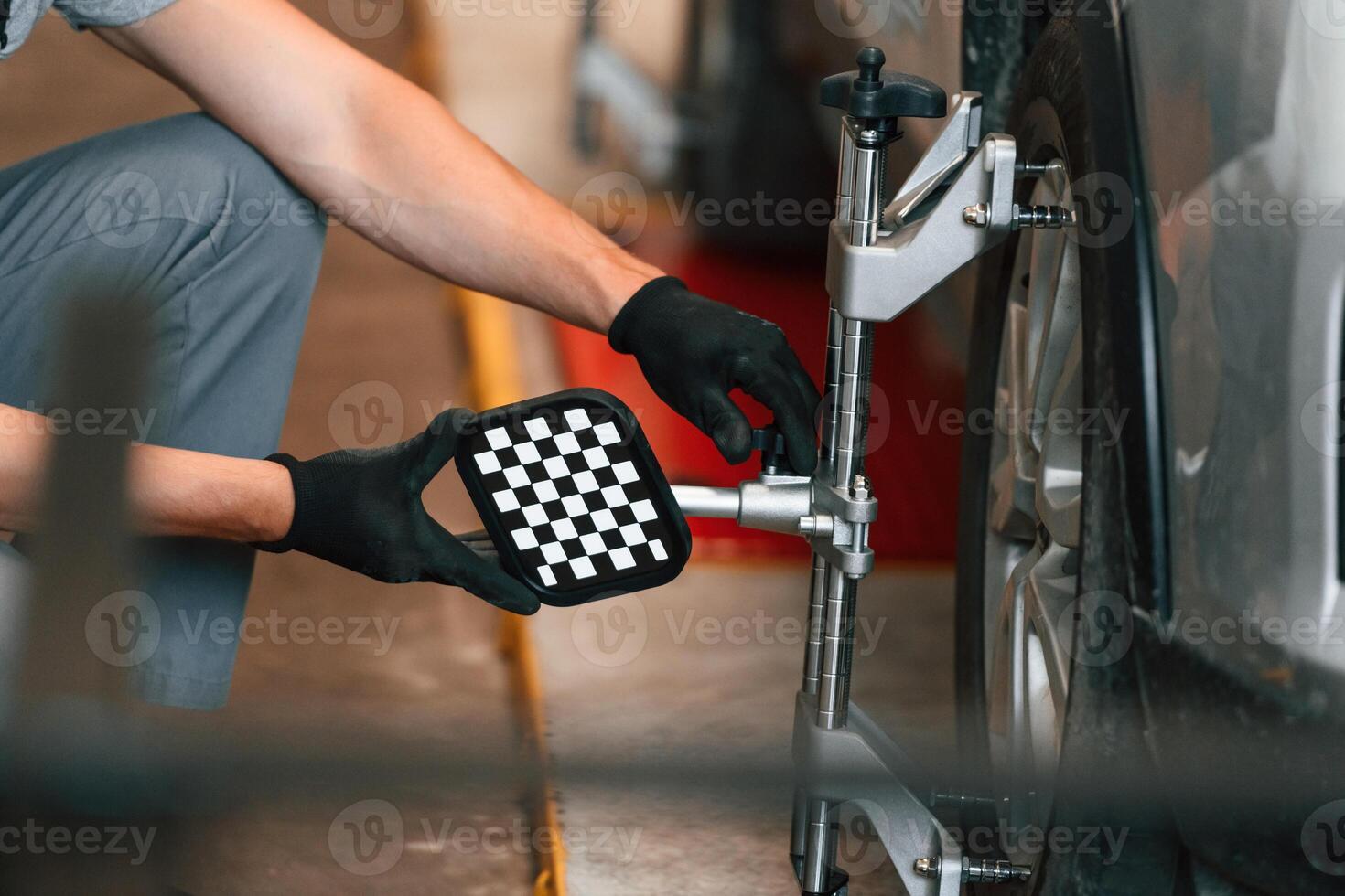 Changing, the tire. Man is works,, in the automobile repairing salon photo