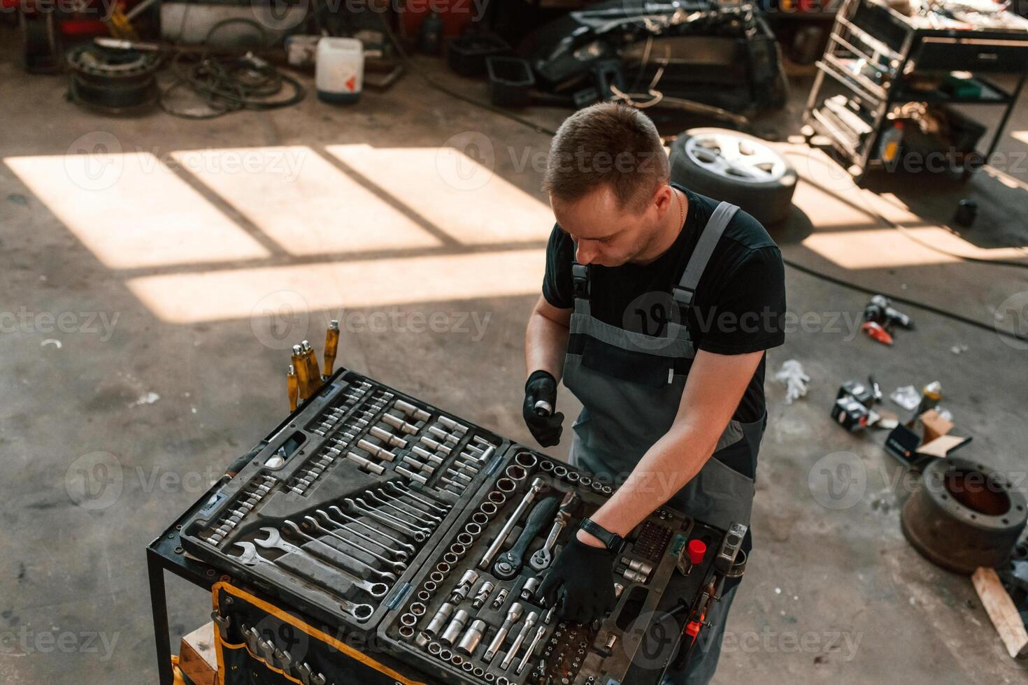 Top, view of ,employee that standing by the toolbox. Man is works in the automobile repairing salon photo