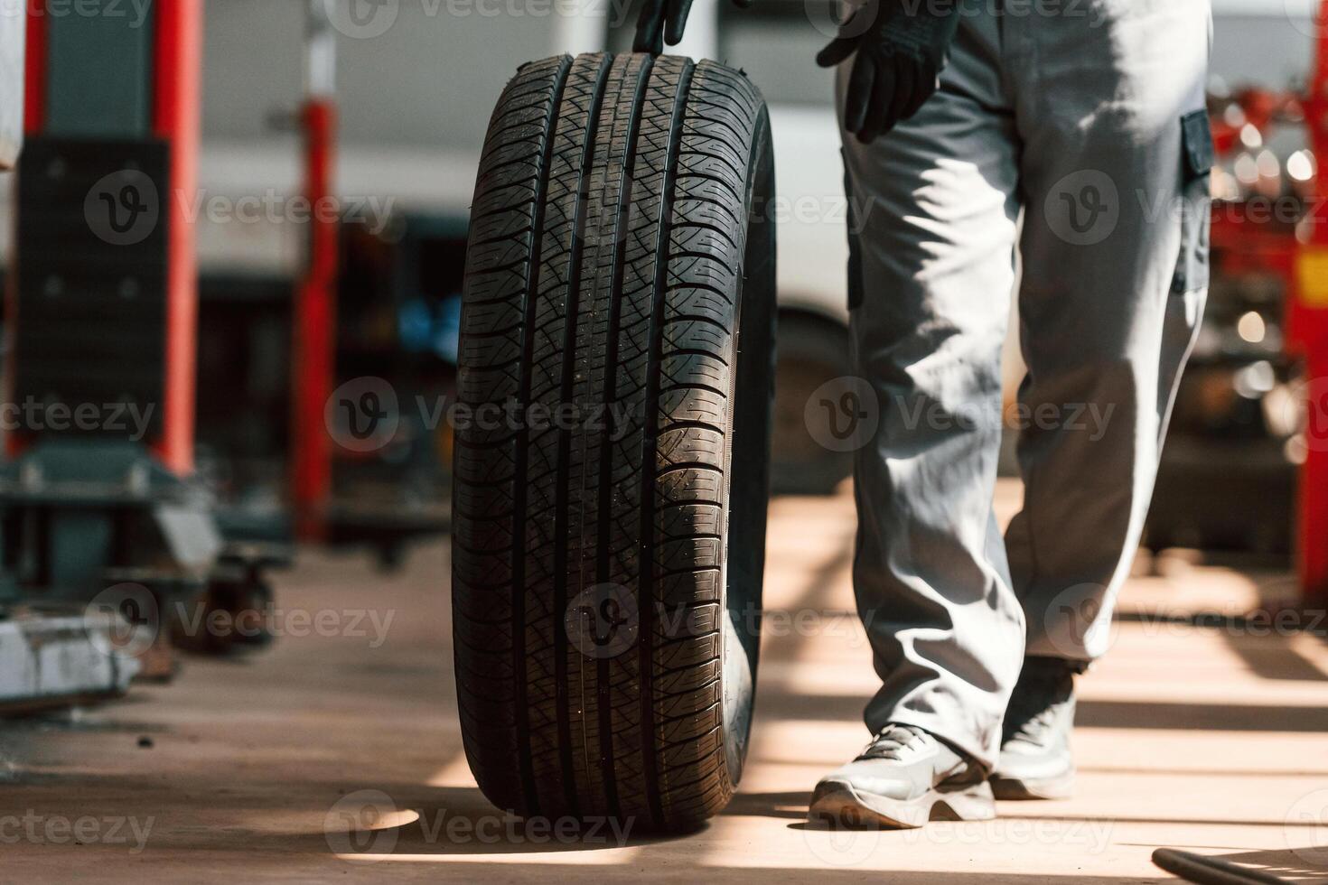 Rolling ,the, wheel. Man is works in the automobile repairing salon photo
