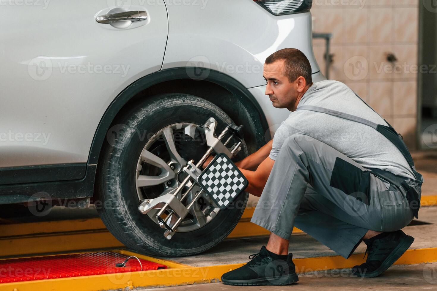 Wheel, changing. Man is works in the automobile repairing salon photo