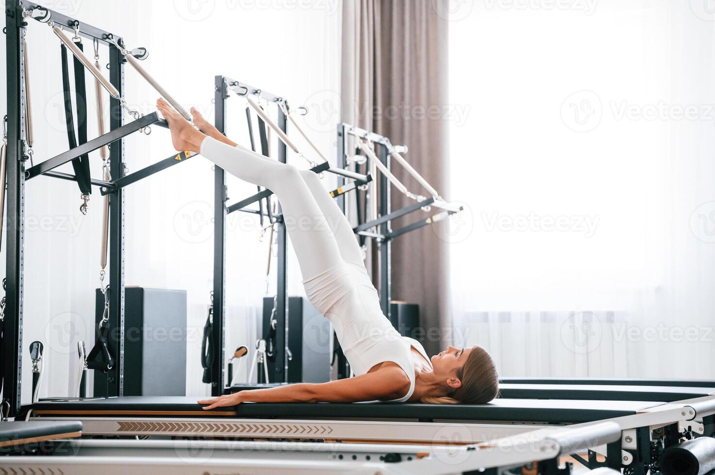Lying down and, stretching legs., Young woman in fitness center is doing exercises photo