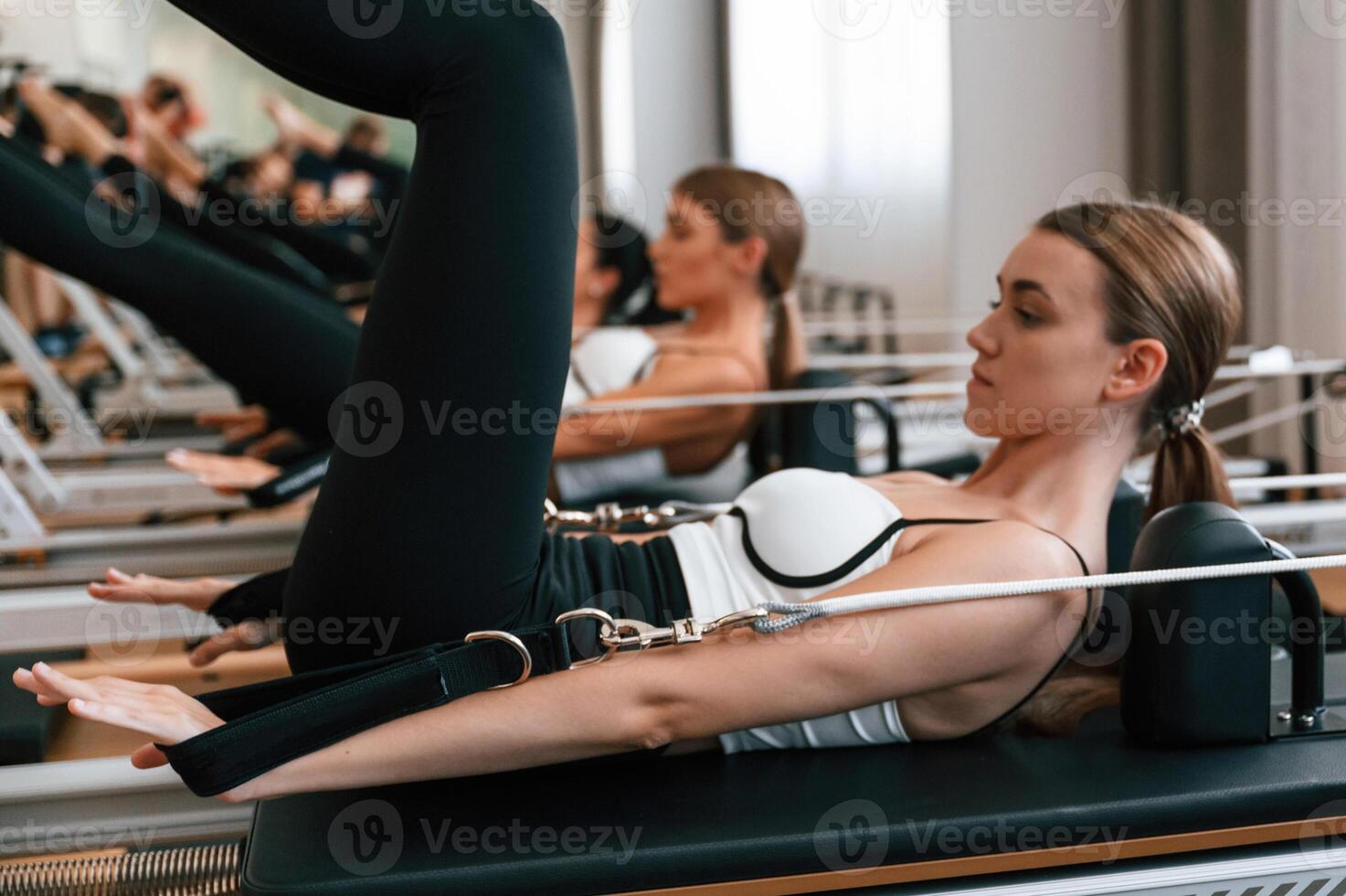 Side view. Stretching the legs., Women ,in fitness center are doing exercises photo