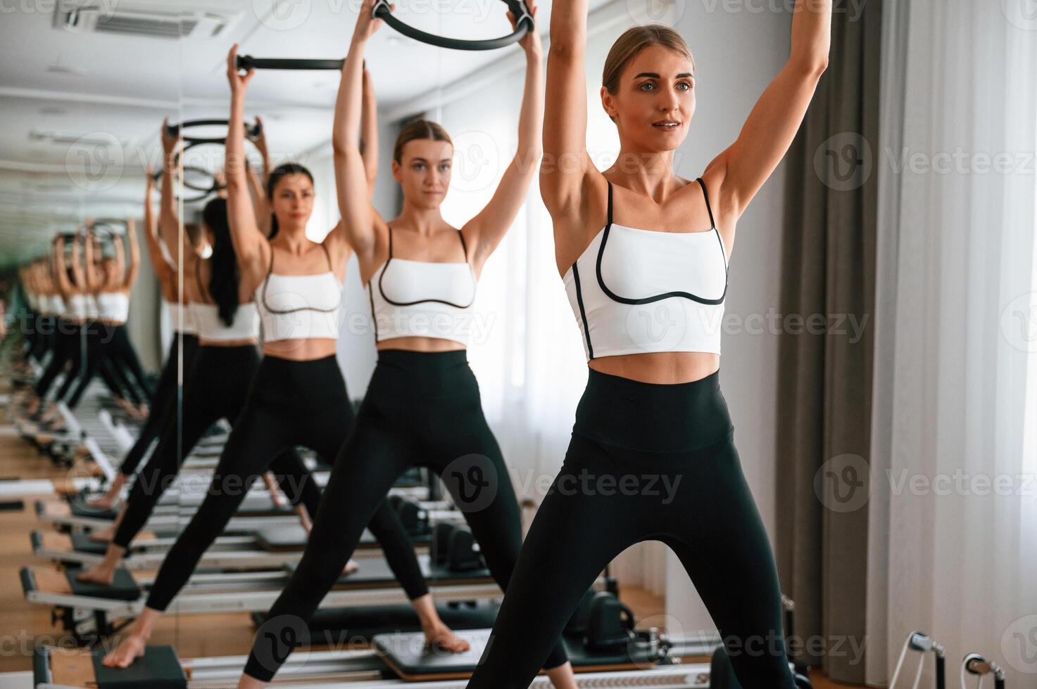 Exercises by ,using the ,circle device in hands. Women in fitness center photo