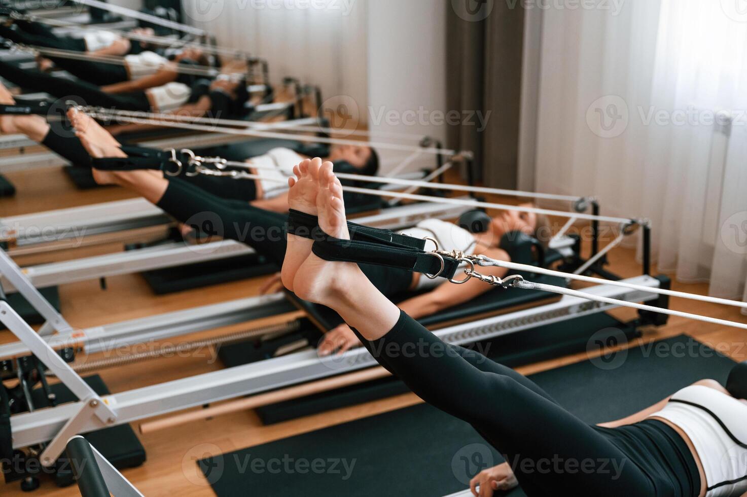 Legs, stretching.. Women in fitness center are doing exercises photo