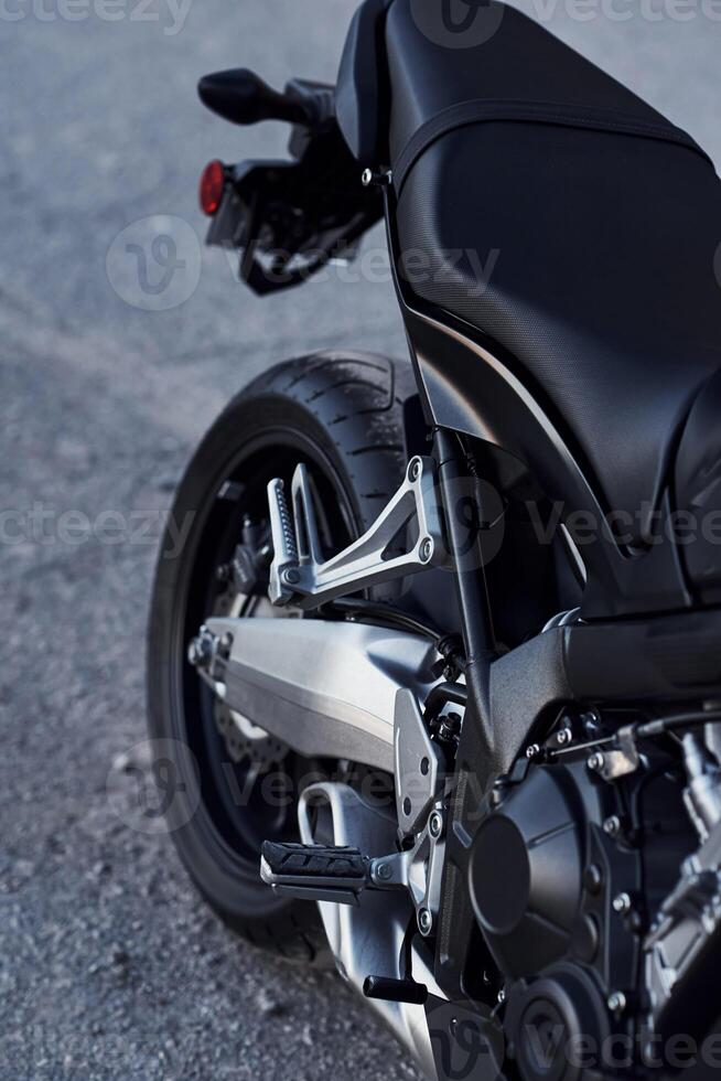 Black colored vehicle. Close up view of modern motorcycle that is parked outdoors photo