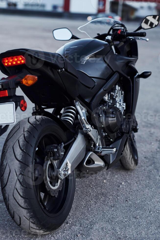 Black colored vehicle. .Close, up view of modern motorcycle that is parked outdoors photo