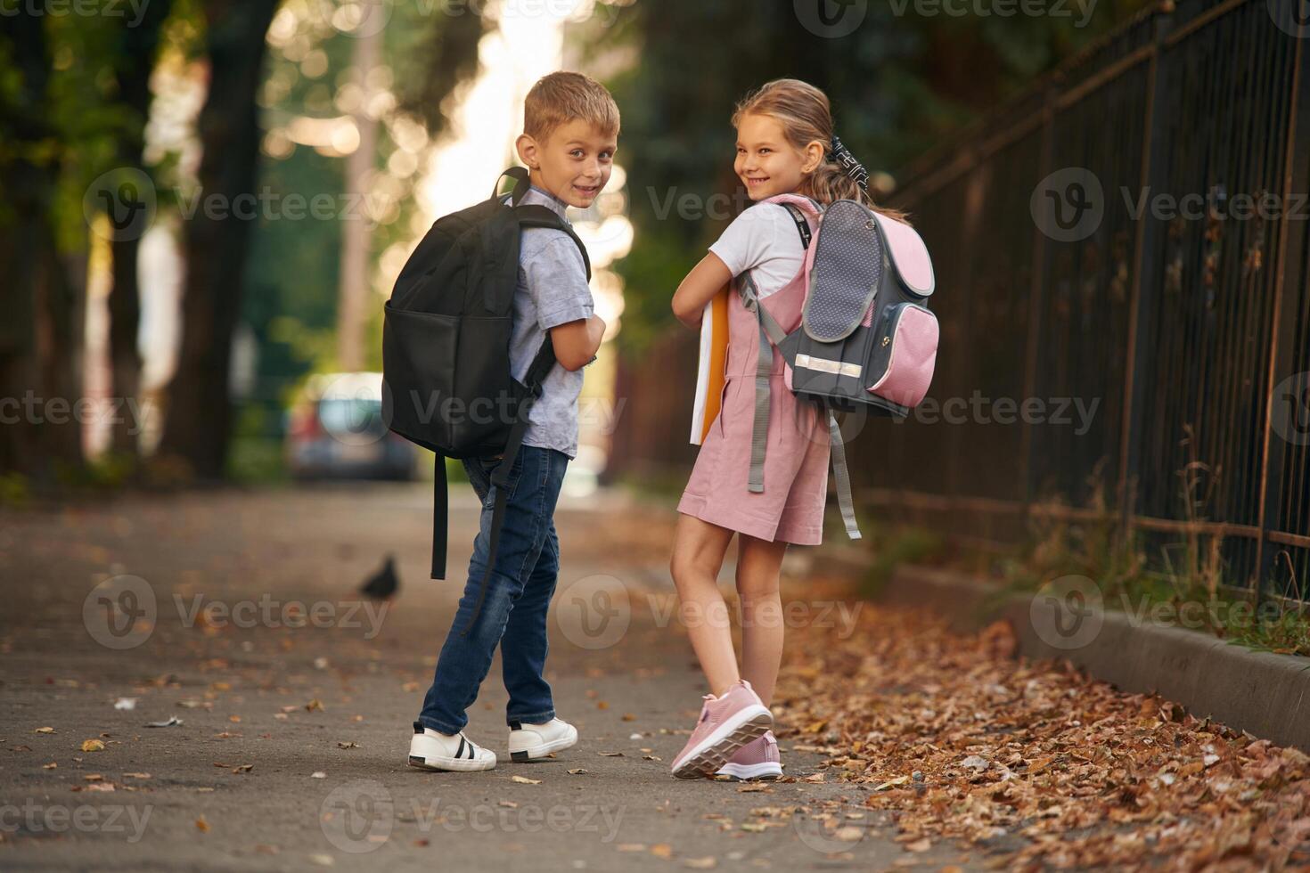 Young school children of boy, and girl are together outdoors photo