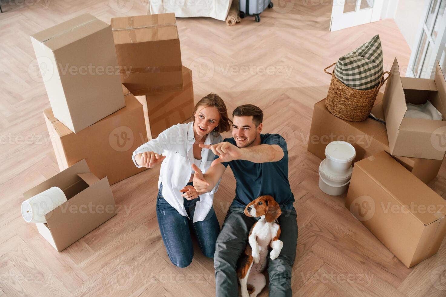 Top view. Young couple with dog are moving to new home photo