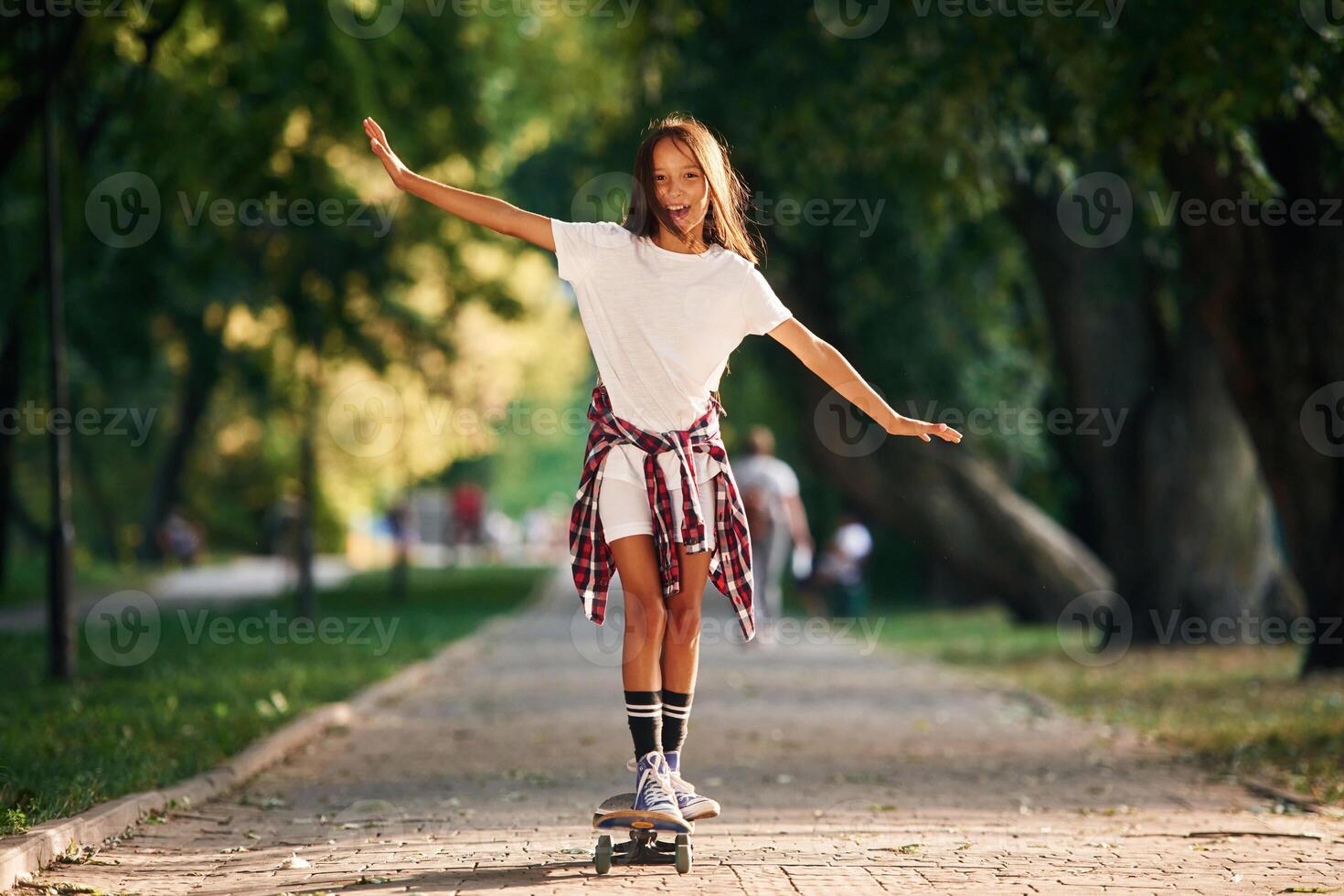 Controlling ,the balance.. Happy little girl with skateboard outdoors photo