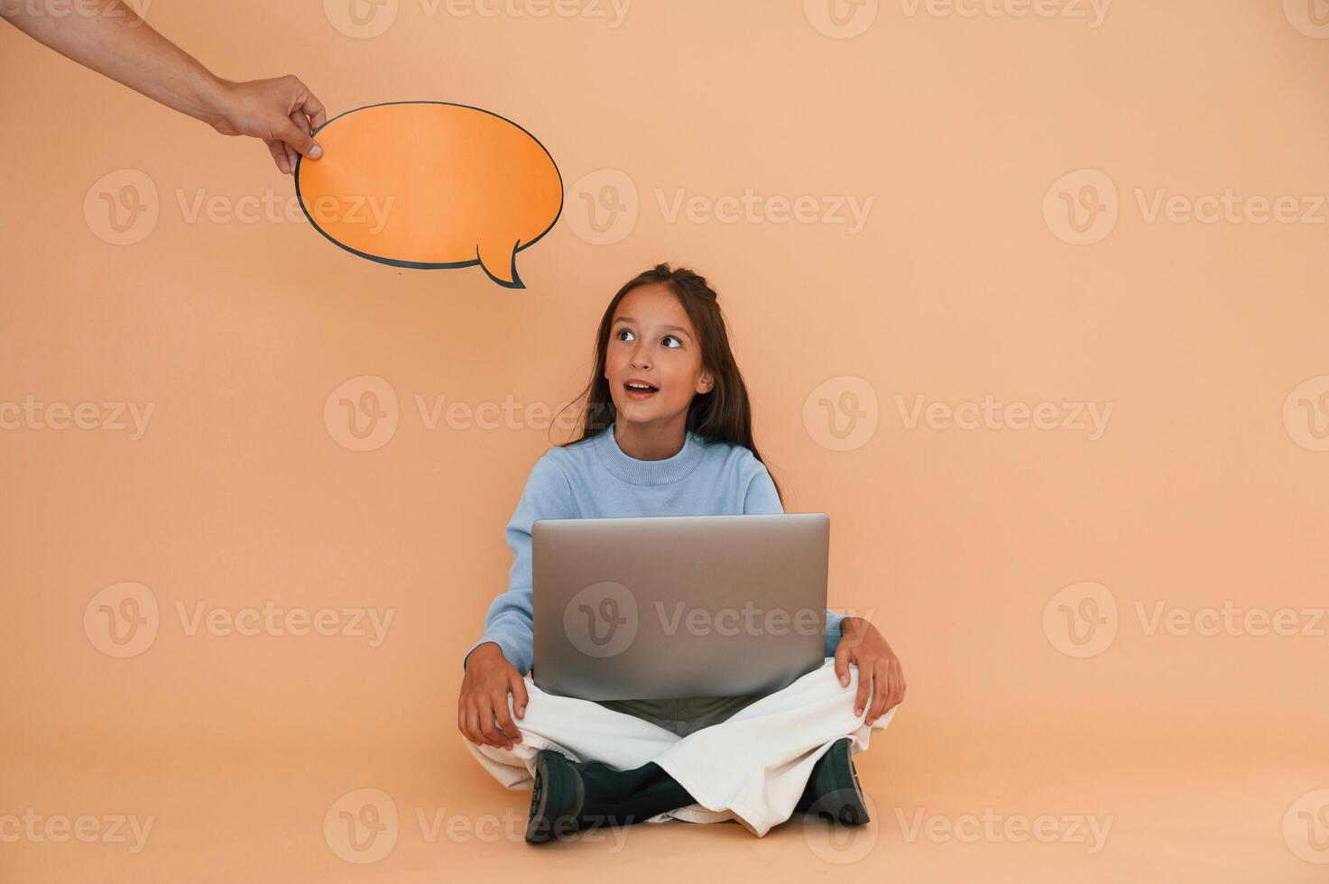 Hand is holding sticker with copy space for text, thoughts. Sitting with laptop. Cute young girl photo