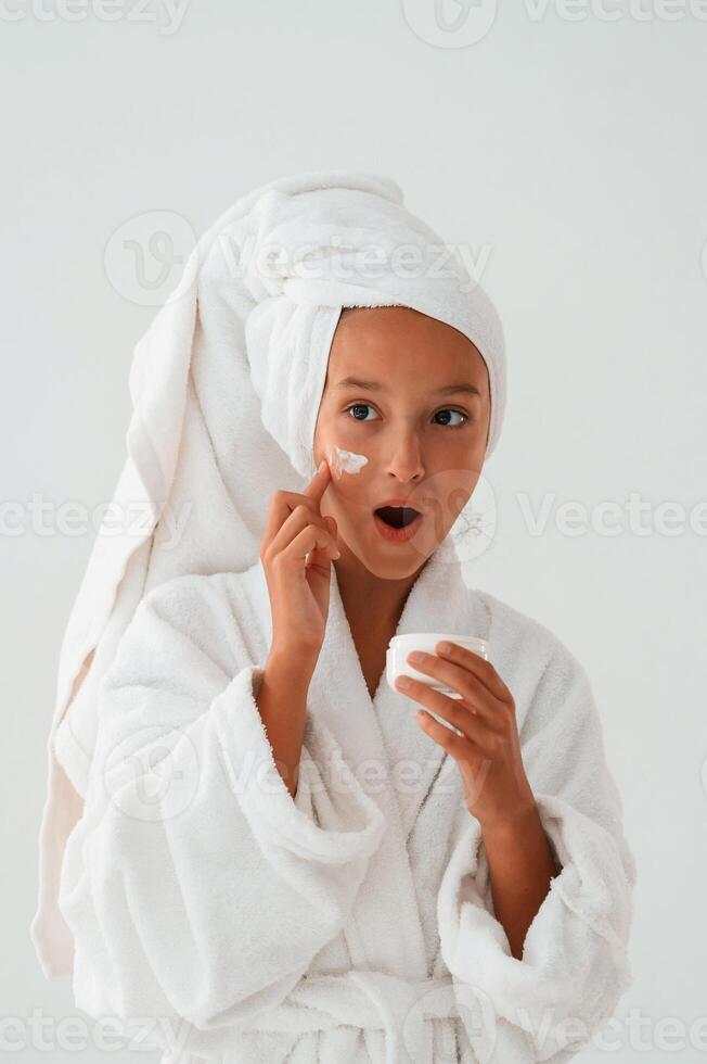 Cream for the face skin. Conception of beauty and self care. Young girl is in the studio photo