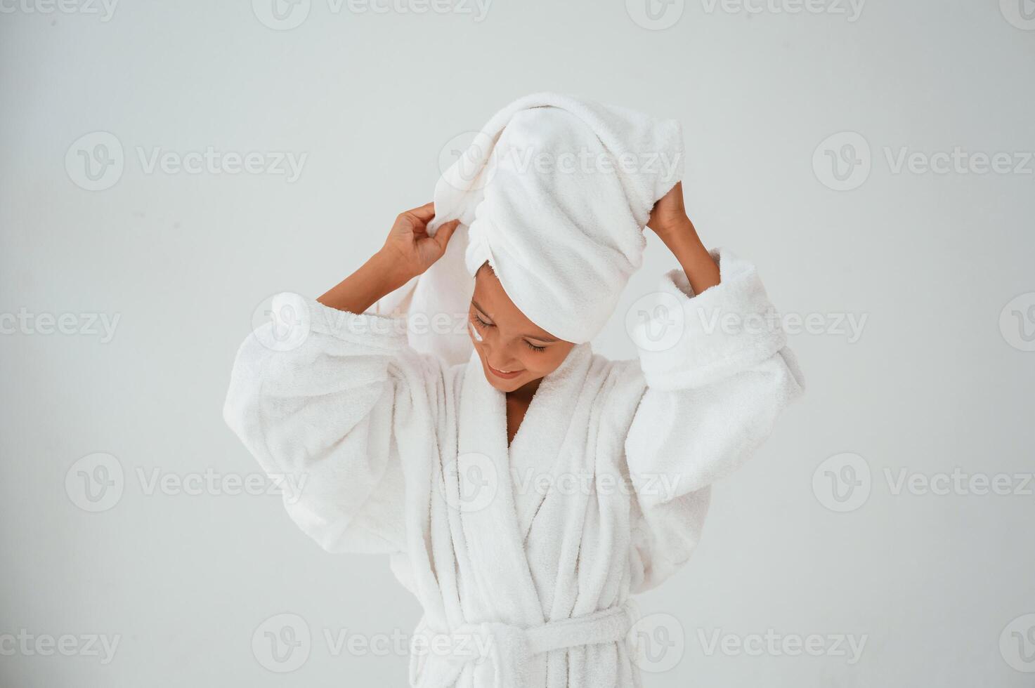 With towel, on the head. Conception of beauty and self care. Young girl is in the studio photo