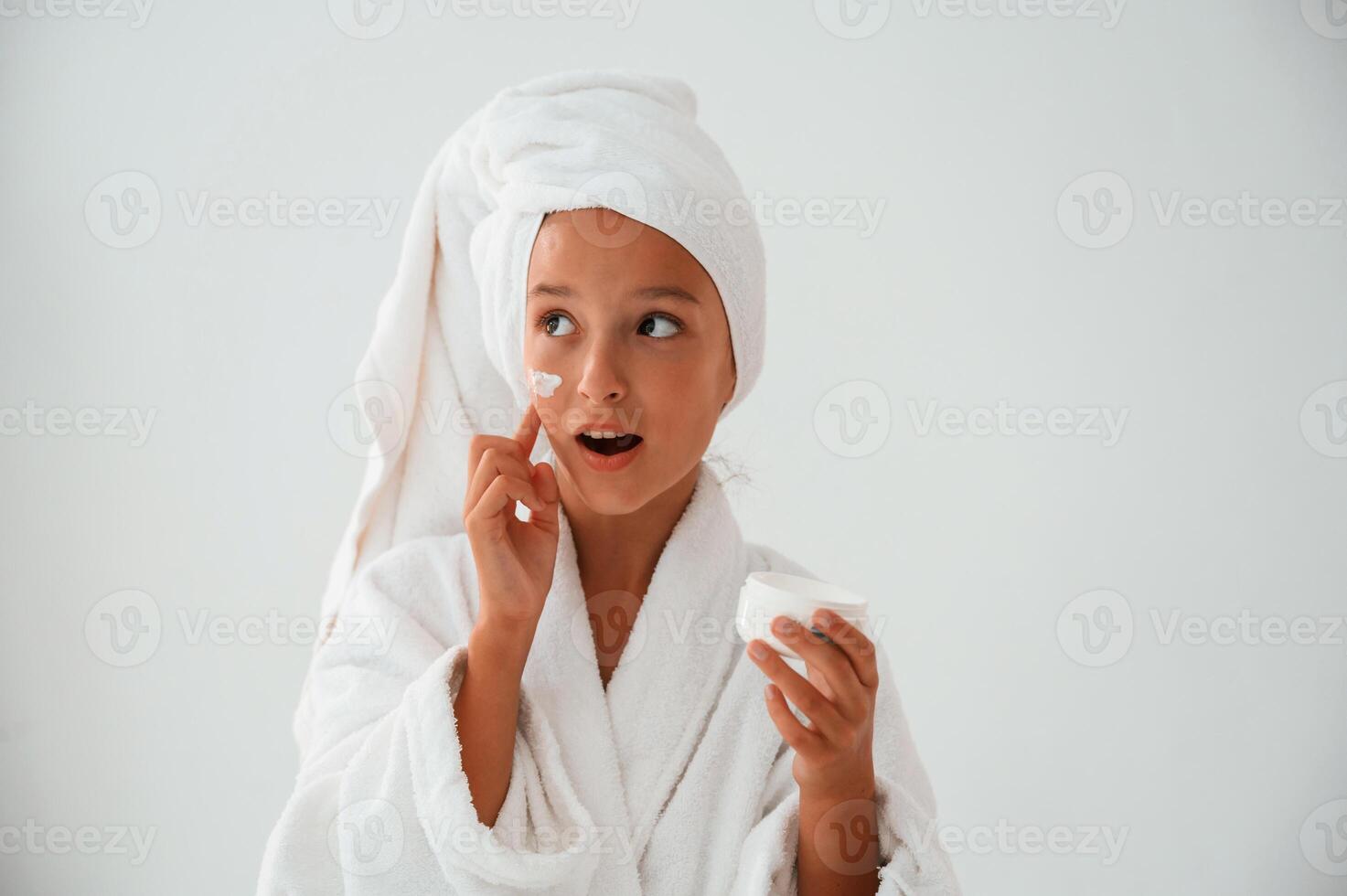 Cream for the face, skin. Conception of beauty and self care. Young girl is in the studio photo
