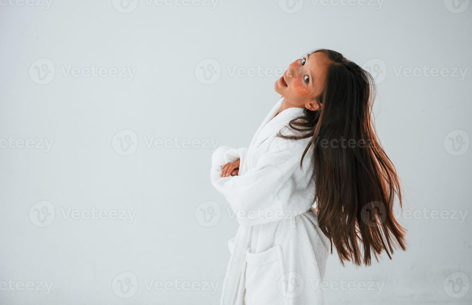 In ,white, robe. Conception of beauty and self care. Young girl is in the studio photo