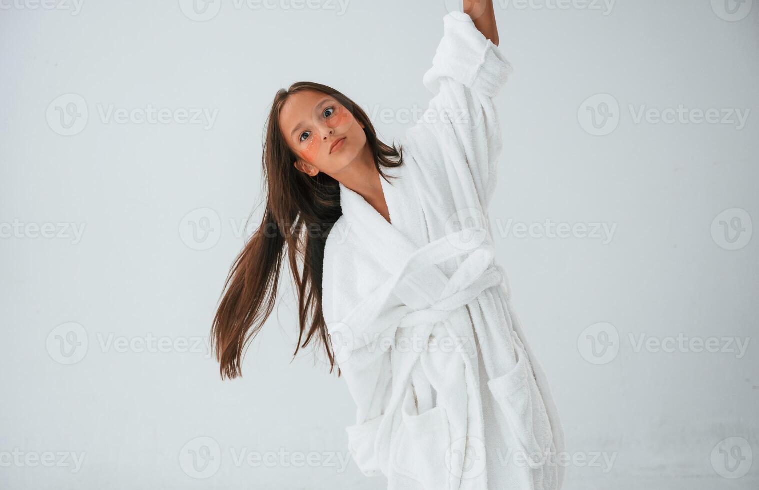 In white robe.. Conception, of beauty and self care. Young girl is in the studio photo