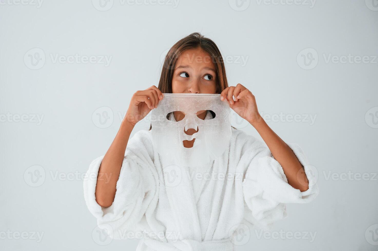 Wearing off ,mask for the face. Conception of beauty and self care. Young girl is in the studio photo