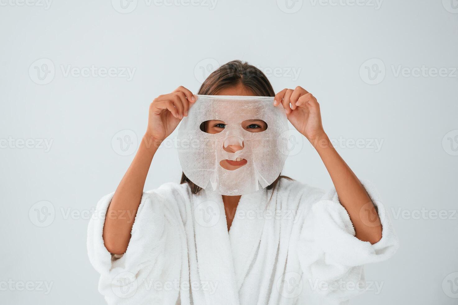 Wearing off mask for ,the face. Conception of beauty and self care. Young girl is in the studio photo